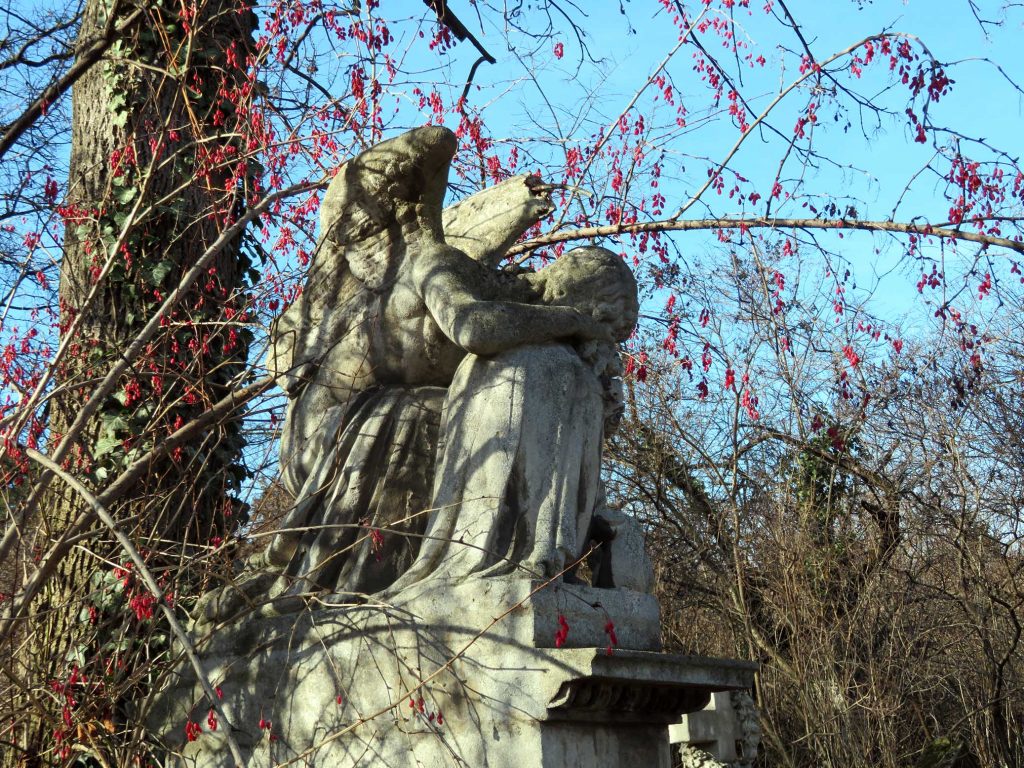 Trauender Engel aus Stein auf einem Grab